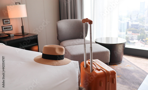 Luggage and hat lay on the bed in the apartment - travel concept