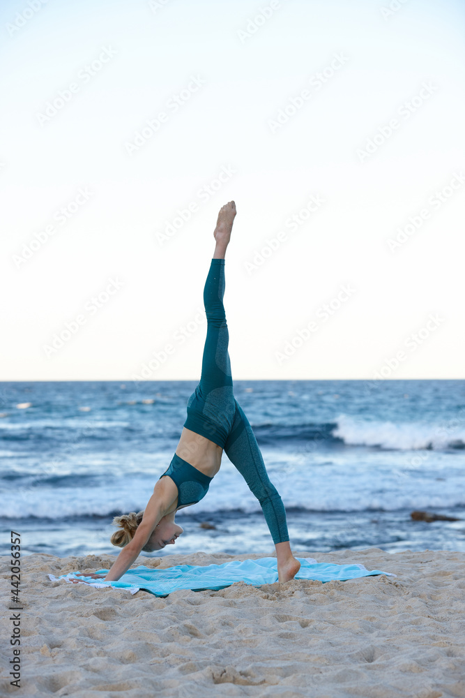 Young blonde-haired woman at beach doing yoga Young blonde-haired woman at beach doing yoga