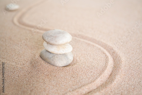 Japanese zen garden stone on wave sand beach. rock or pebbles with copy space. for aroma therapy spa on summer holidays. meditation wellness and tranquility Japanese concept.