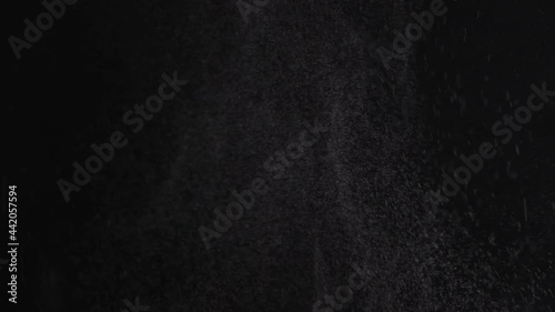 Slow motion. Spraying water droplets. Fallow jet is emitted from the humidifier. Illuminated steam on dark background