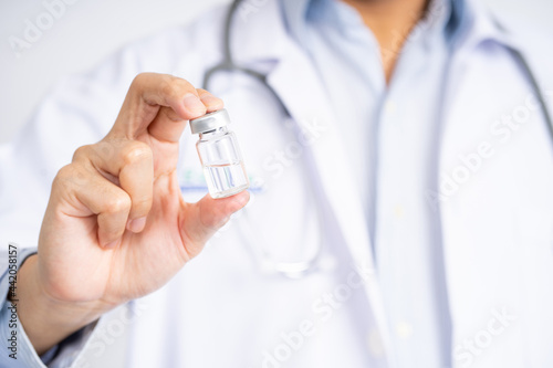 Close-up of a doctor's hand holding a bottle of covid-19 vaccine. Health and medical concepts.