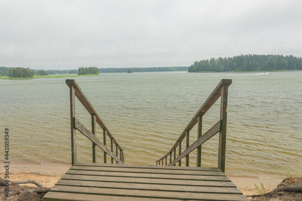 Obraz premium Wooden stairs to the seashore. Sandy beach, pine forest. Scandinavian nature. Finland. Porvoo