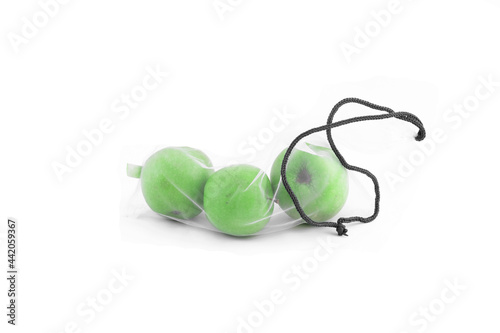Three ripe healthy green apples in a reusable shopping bag on a white background