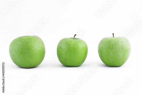 Three ripe healthy green apples on a white background