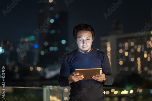 Photography Asian creative freelancer using technology tablet with smile action in the finan