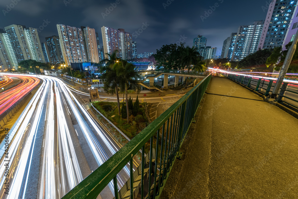 Light trail of traffic on highway and pedestrian walkway in Hong Kong city at night