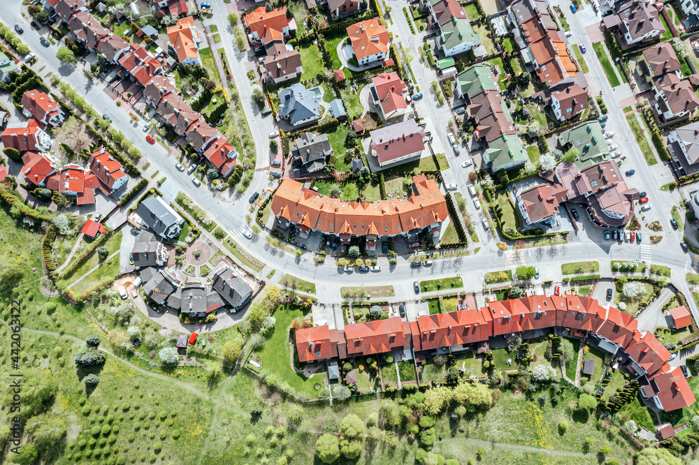 Fototapeta premium aerial top view of residential houses in suburban area at sunny summer day