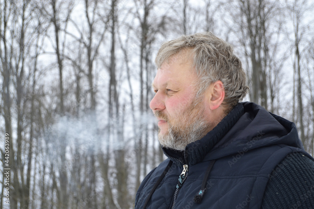 A gray-haired man in a winter forest. Cold. Steam is coming out of my mouth.