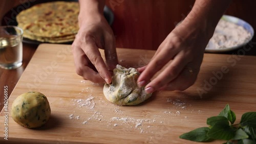 Preparation of Aloo Paratha or roti parantha chapati  4K slow motion video footage Punjab, North India. Female hand rolling whole wheat dough mashed potato stuffing rolling pin vegetarian Indian food  photo