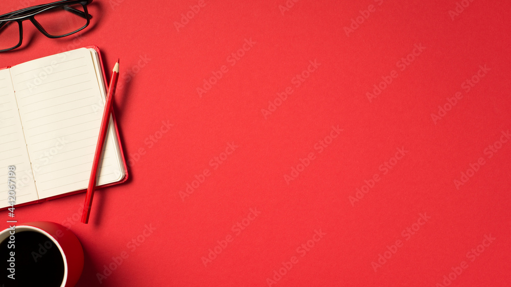 Top view photo of open red organizer pencil glasses and red cup of coffee on isolated vivid red background with copyspace
