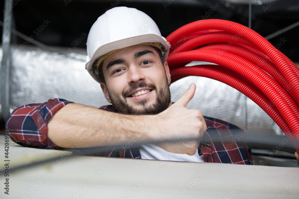 happy builder in roof space showing thumbs up happy builder in roof space showing thumbs up