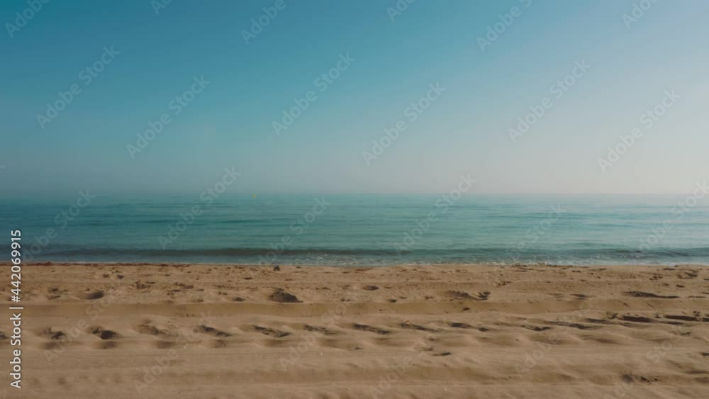 Empty beach with soft sea waves washing on the shore Empty beach with soft sea waves washing on the shore