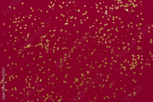 Gold glitter stars on a dark red background