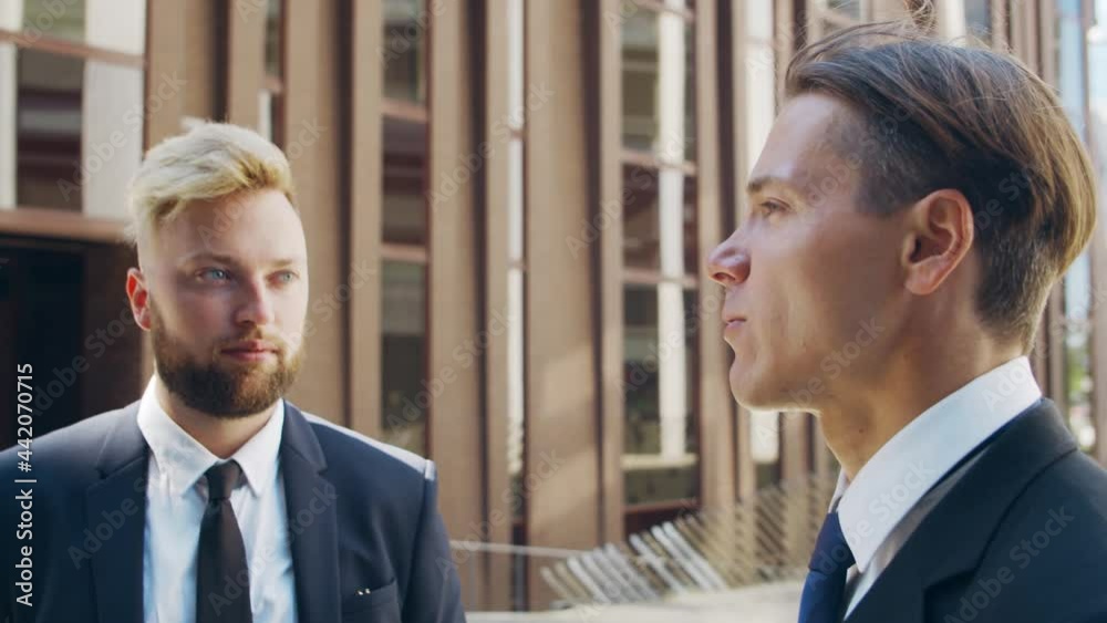 Confident businessman and his colleague in front of modern office building. Financial investors are talking outdoor. Banking and business. Confident businessman and his colleague in front of modern office building. Financial investors are talking outdoor. Banking and business.