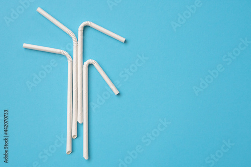 Biodegradable eco friendly white paper drinking straw on blue background