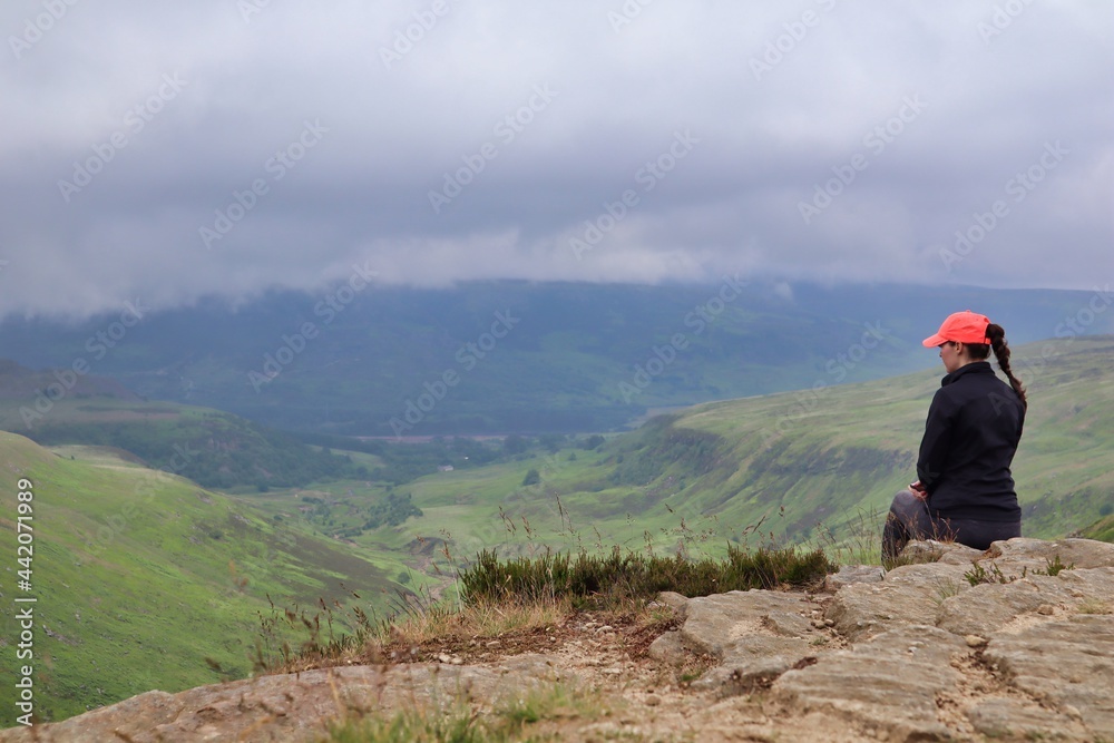 Girl female woman sat on ledge rock countryside view cliff