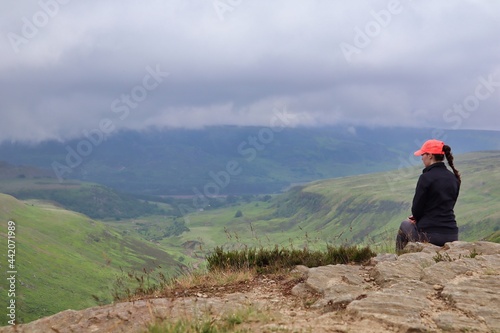 Girl female woman sat on ledge rock countryside view cliff