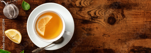 Panel kuchenny z motywem Lemon tea panorama with a strainer, top shot on a dark rustic wooden background with a place for text. Healthy vegan morning drink