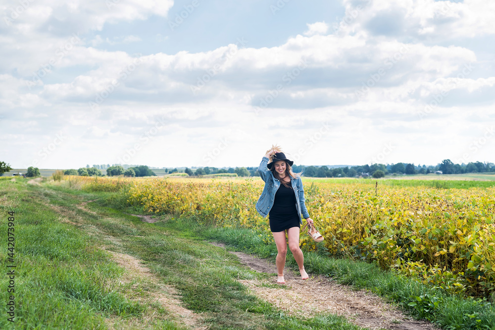 Beautiful carefree woman posing in rural fields  in summer