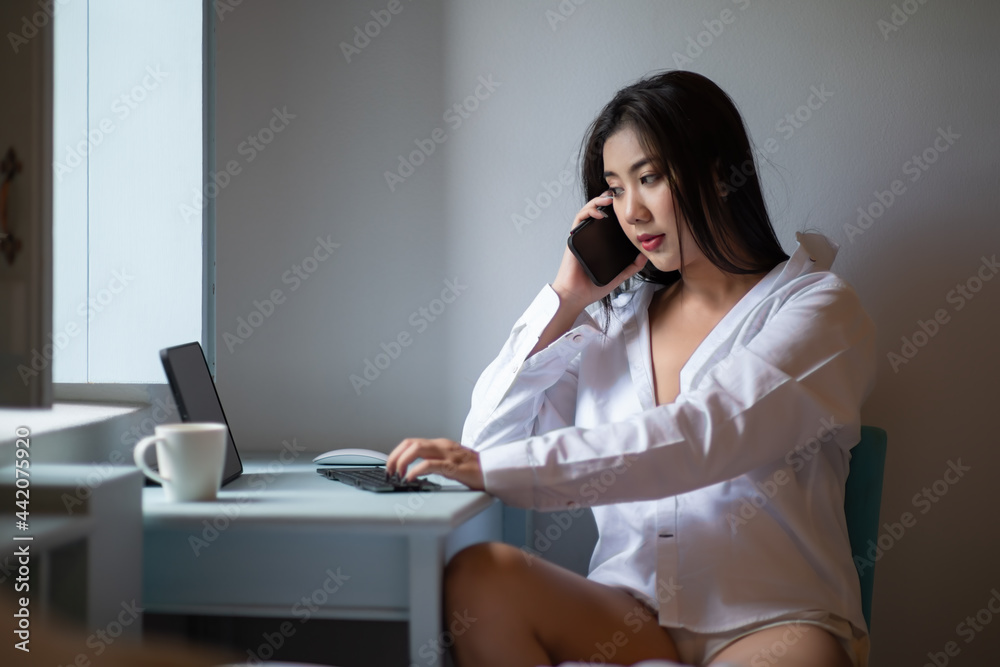 Asian woman using the smart phone at the living room. Asian woman using the smart phone at the living room.