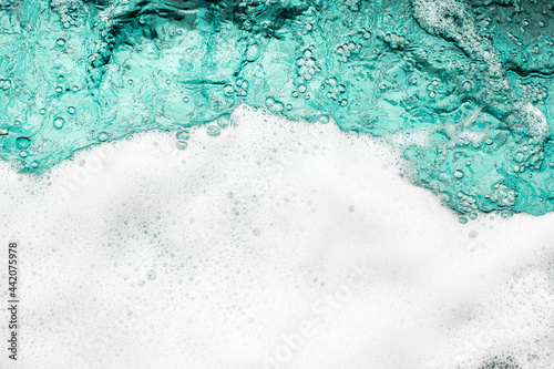 Blue sea water white foam texture background closeup, foamy ocean wave pattern, aqua bubbles surface, swimming pool backdrop, abstract summer sunny beach wallpaper, decorative frame border, copy space