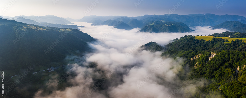Cerkev Marijinega, Slovenia - Aerial panoramic view of a sunny and cloudy summer morning in the Slovenian alps with Church of Mary (Cerkev Marijinega) and Slovenian alps at background