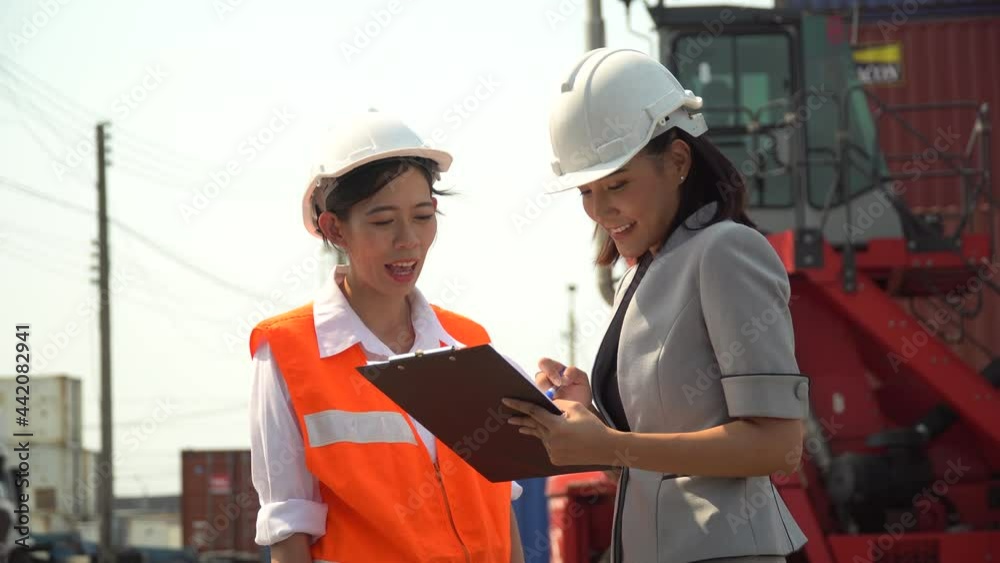 asian harbor worker and manager woman discussion and using clipboard checking list inventory loading Containers box at warehouse logistic in Cargo . import export freight shipping . forklift moving asian harbor worker and manager woman discussion and using clipboard checking list inventory loading Containers box at warehouse logistic in Cargo . import export freight shipping . forklift moving