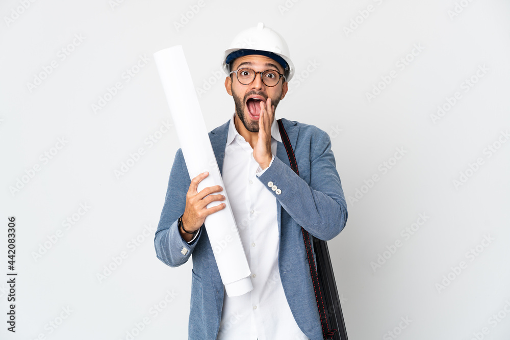 Young architect man with helmet and holding blueprints isolated on white background with surprise and shocked facial expression Young architect man with helmet and holding blueprints isolated on white background with surprise and shocked facial expression