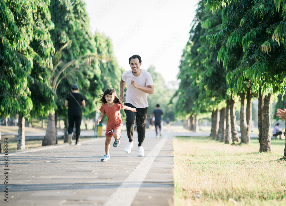 father and daughter do exercises running outdoor racing each other. Healthy lifestyle of family with child father and daughter do exercises running outdoor racing each other. Healthy lifestyle of family with child