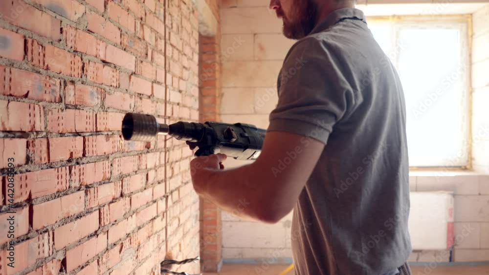 A construction worker works with a puncher close up. A construction worker works with a puncher close up.