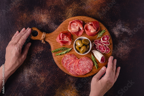 Serving board with a set of different meat snacks. photo