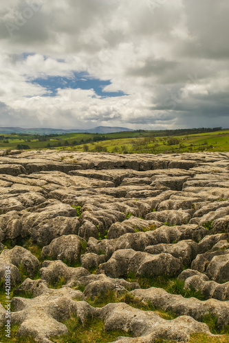 Limestone pavement above Malham Cove, Yorkshire Dales with a view in the distance of the dales