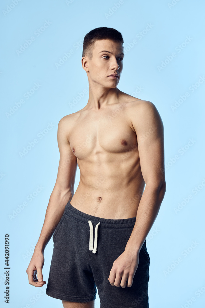 handsome man with a pumped-up naked torso look to the side blue background handsome man with a pumped-up naked torso look to the side blue background