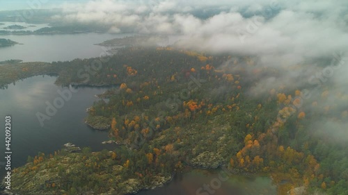 Bird’s eye view Ladoga lake skerries foggy picturesque natural landscape Karelia Russia Finland autumn forest. Impressive cloudy costal scenery. Above clouds unique travel willife footage. Swampy wood photo
