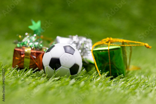 Soccer ball with Christmas Decoration are on green grass