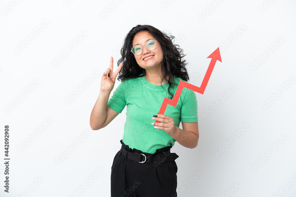 Young asian woman isolated on white background holding a catching a rising arrow and celebrating a victory Young asian woman isolated on white background holding a catching a rising arrow and celebrating a victory