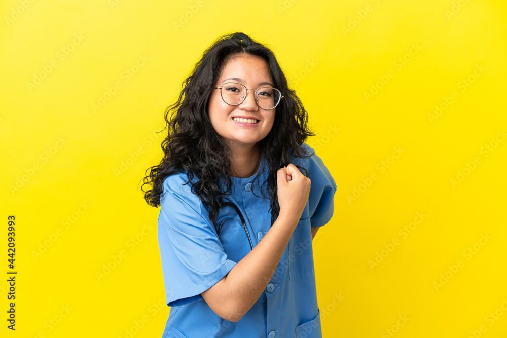 Young surgeon doctor asian woman isolated on yellow background celebrating a victory