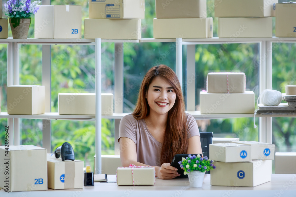 Beautiful young woman in brown shirt happily in business office of delivery services. Beautiful young woman in brown shirt happily in business office of delivery services.