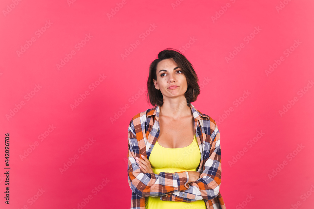 Beautiful fit woman in yellow bright fitting sportswear and plaid shirt on pink background sad unhappy disappointed Beautiful fit woman in yellow bright fitting sportswear and plaid shirt on pink background sad unhappy disappointed