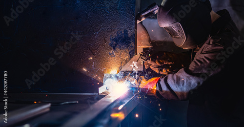 Industry banner, professional worker welder in protect mask use erecting technical iron at work © Parilov