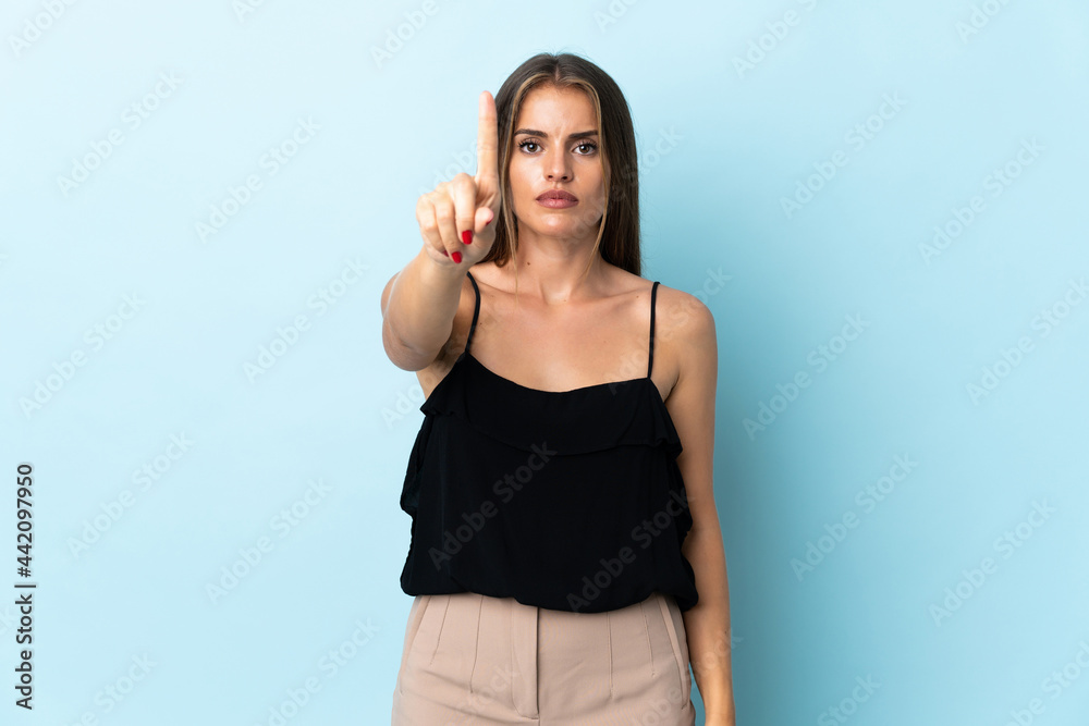 Young Uruguayan woman isolated on blue background counting one with serious expression