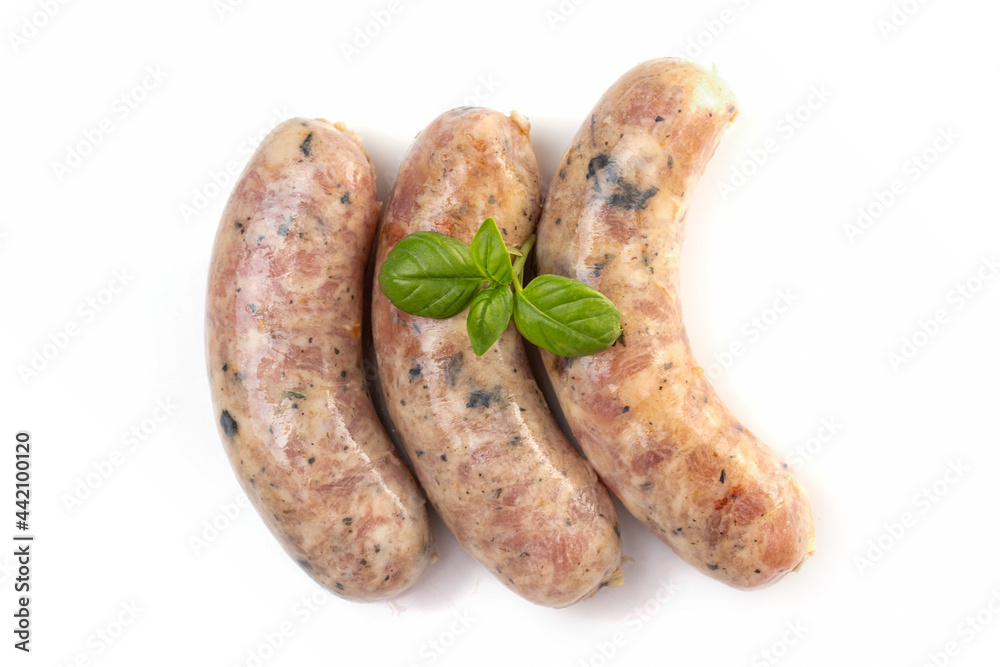 Raw or cooked homemade breakfast sausages decorated with basil leaves, isolated on a white background Raw or cooked homemade breakfast sausages decorated with basil leaves, isolated on a white background