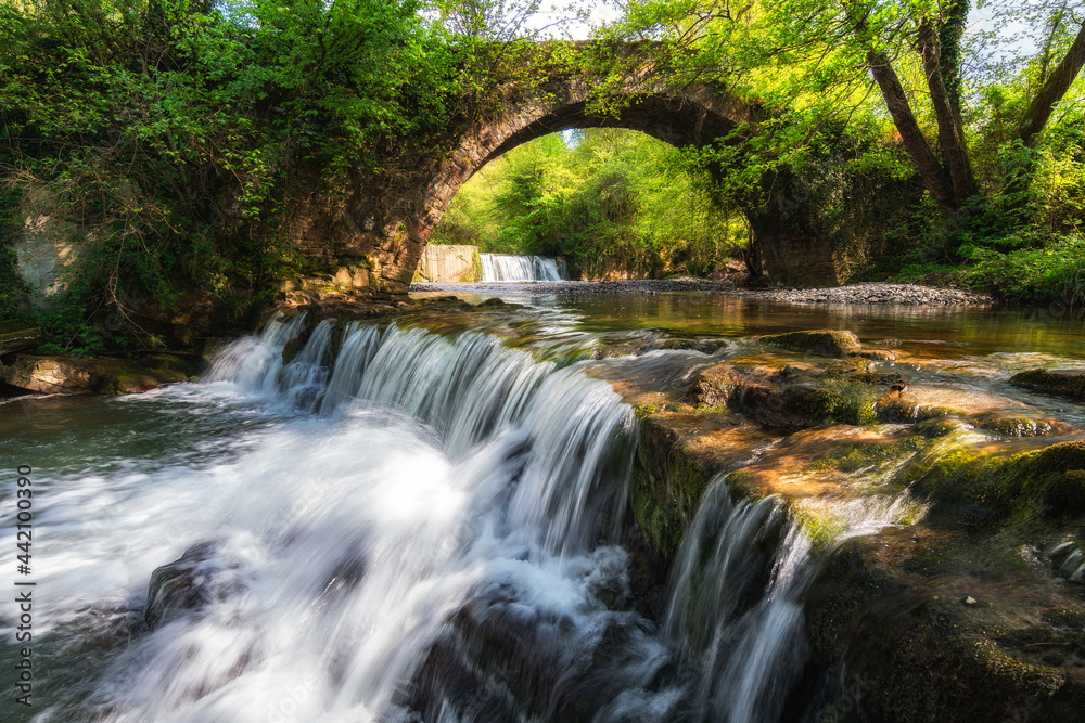 water flowing at river with roman bridge at background water flowing at river with roman bridge at background