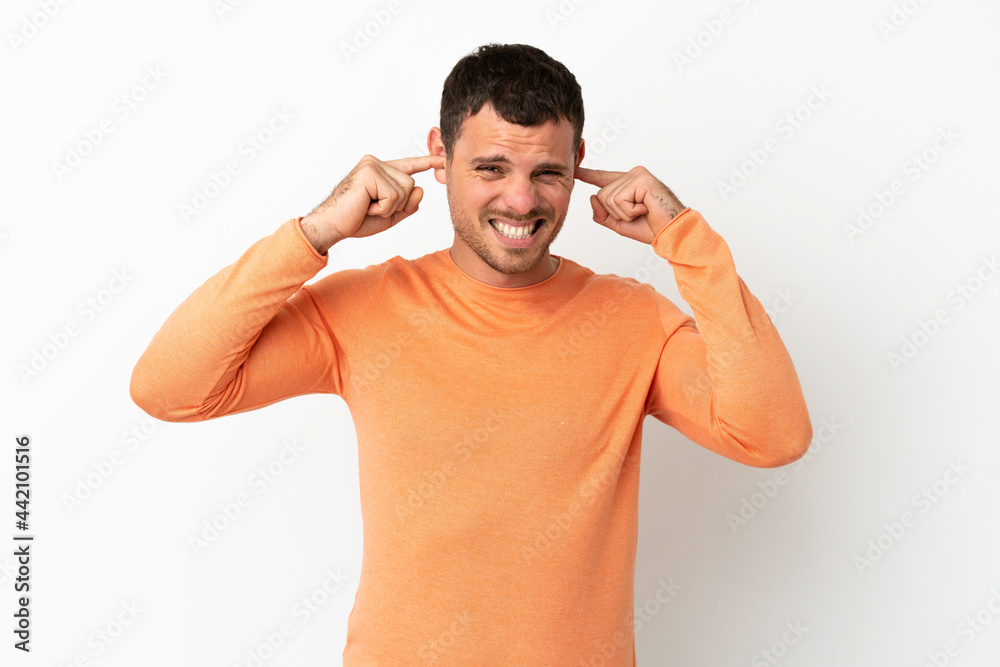 Brazilian man over isolated white background frustrated and covering ears Brazilian man over isolated white background frustrated and covering ears