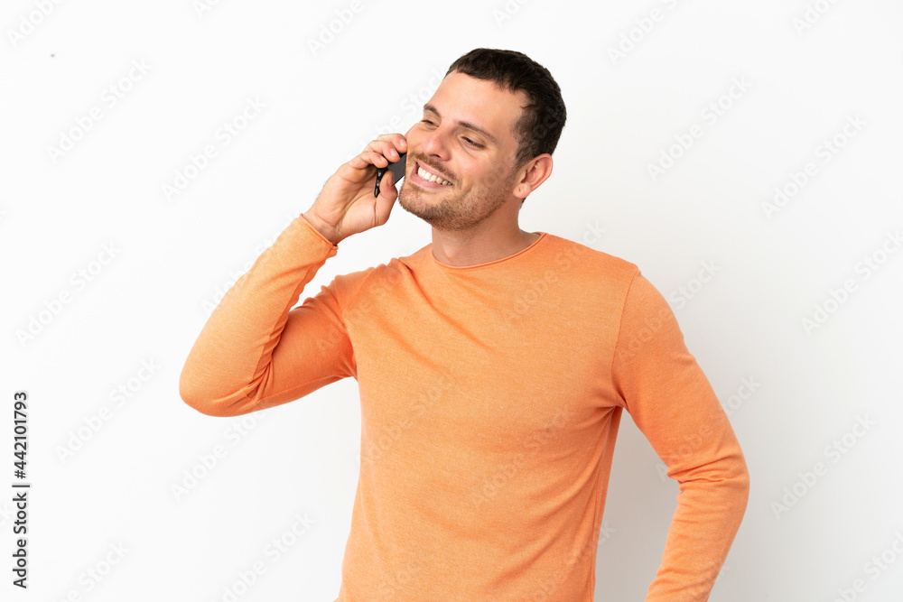 Brazilian man over isolated white background keeping a conversation with the mobile phone Brazilian man over isolated white background keeping a conversation with the mobile phone