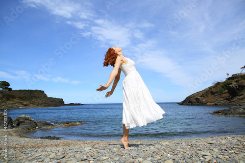 Happy woman in white breaths smiling on the beach