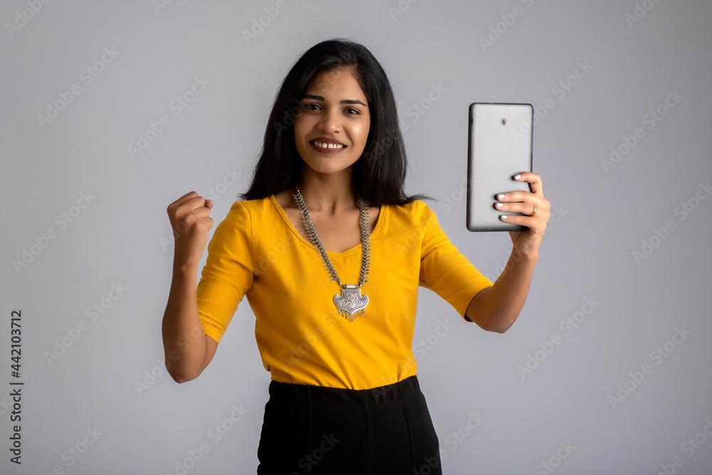Young girl using mobile phone or smartphone on gray background Young girl using mobile phone or smartphone on gray background