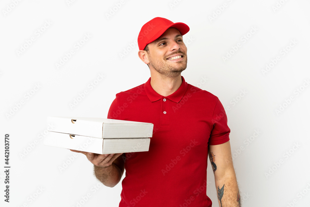 pizza delivery man with work uniform picking up pizza boxes over isolated white wall thinking an idea while looking up pizza delivery man with work uniform picking up pizza boxes over isolated white wall thinking an idea while looking up