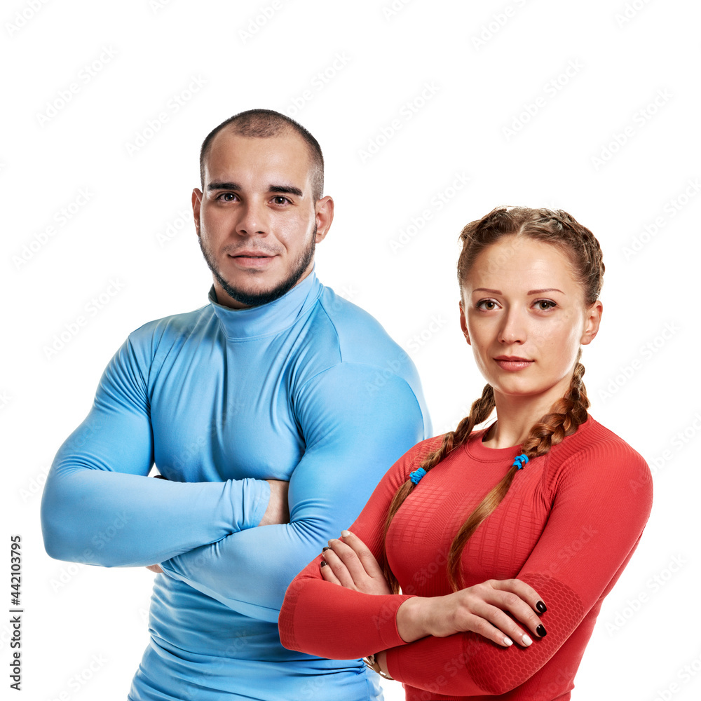 Obraz premium Young happy athletic man and woman posing after training on white background, healthy lifestyle, the need for physical activity in the modern world