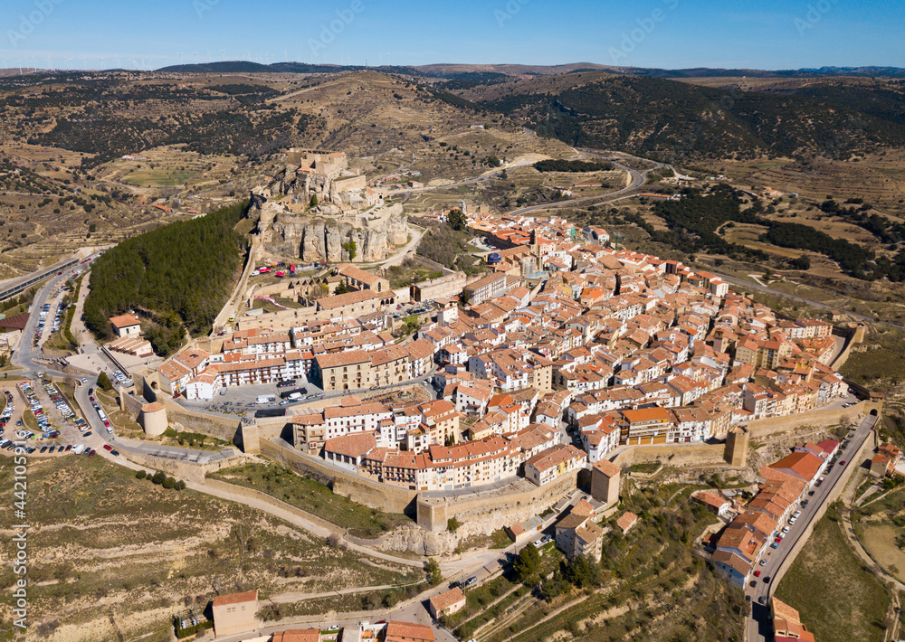 Aerial view of Morella cityscape with ancient fortified castle on top of rock in sunny day, Spain..